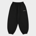 Black sweatpants with a brand logo on a light gray background